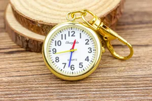 Montre infirmière dorée avec chiffres clairs, mouvement à quartz et attache par clip sécurisée.