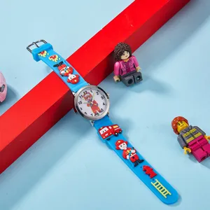Détail de montre à quartz pompier enfant, bracelet en silicone bleu avec motif de dessin.