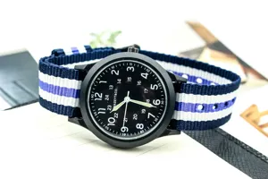 Black dial nylon strap military quartz watch detail view showcasing clear white numbers and band.