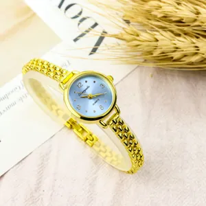 Elegant women gold quartz watch with small blue dial and chain strap, fashion chic accessory.
