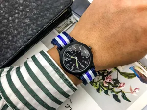Detail view of fashion nylon strap military watch with black dial and luminous hands for kids.