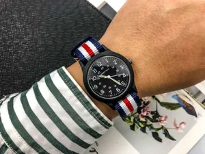 Detailed close-up of a nylon strap quartz watch with black dial and clear Arabic numerals.