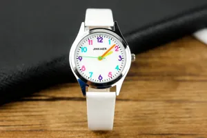 Primo piano dell'orologio da bambini con quadrante bianco, numeri colorati e cinturino bianco.