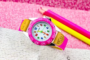 Detail kinderhorloge quartz, roze bezel met kleurrijke cijfers en leren band met smiley.