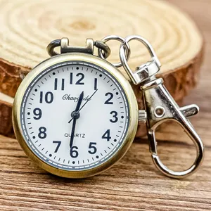 Montre infirmière vintage avec chiffres arabes clairs, mouvement à quartz et clip métallique.