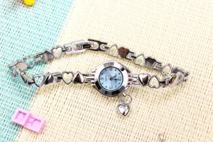 Montre quartz femme chaîne cœur argentée avec cadran bleu clair et joli pendentif.