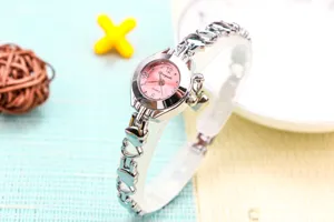 Montre quartz femme argentée avec bracelet chaîne cœur évidé et cadran rose élégant et chic.