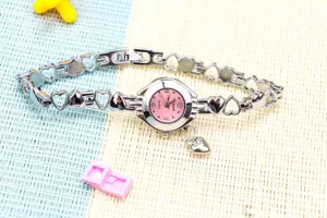 Photo de détail exquise d'une montre à quartz pour femme en chaîne de cœur creux argentée.