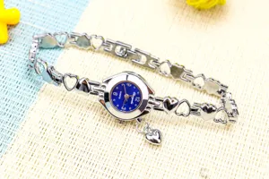 Vue de détail en gros plan de la montre quartz chaîne cœur creux femme cadran bleu.