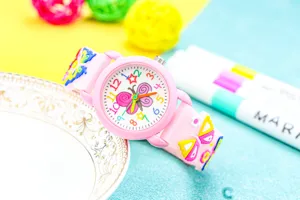 Close-up of cute pink kids quartz watch featuring 3d butterfly dial detail and colorful strap.