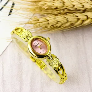 Details of women minimalist quartz watch, small oval pink dial, gold heart bracelet strap.