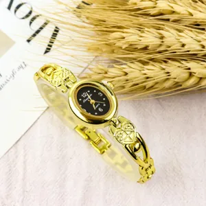 Vintage gold-tone women's quartz bracelet watch with an elegant oval dial and heart links.