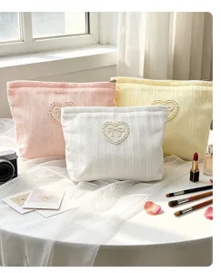 Detail view of aesthetic ins-style corduroy cosmetic bag with sweet heart bow applique.