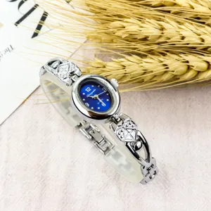 Women vintage quartz watch with oval blue dial and cute heart link metal bracelet strap.