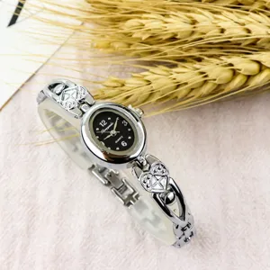 Women vintage quartz watch with oval black dial and cute heart bracelet strap. Elegant style.