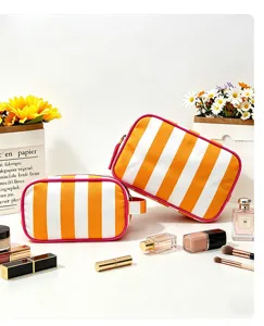 Detail view of orange white striped cosmetic makeup bag, portable travel storage pouch setup.