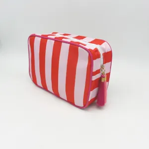 Close-up view of the red and pink striped cosmetic bag showing the zipper and tassel detail.