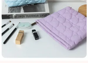 Detailed view of the light purple quilted heart makeup pouch with soft fabric and metal zipper.