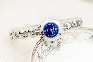 Montre à quartz élégante pour femme avec cadran bleu et bracelet chaîne cœur argenté usage quotidien.