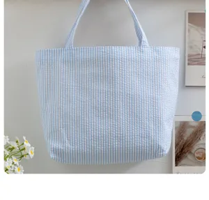 Detail view of blue and white striped tote bag, casual summer style handbag with soft texture.