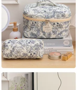Detailed view of quilted cotton makeup bag in blue floral print, aesthetic vanity organizer.