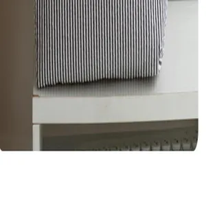 Close-up view of black and white vertical striped fabric texture on white shelf surface.
