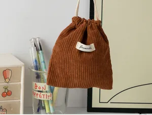 Close-up view of the soft brown corduroy drawstring pouch showing detailed texture and design.