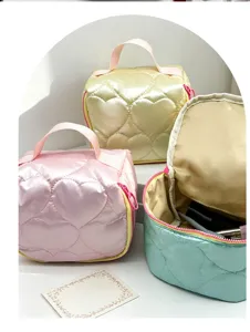 Close-up detail of cute quilted heart cosmetic bags in pastel colors with portable handles.