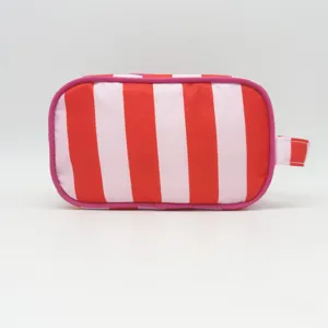 Close up view of the red and pink striped cosmetic pouch detail, showing durable fabric texture.
