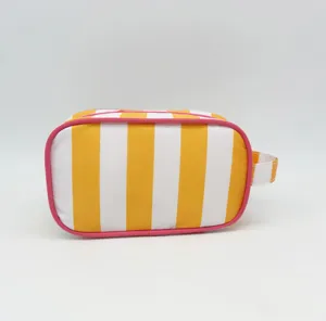Close-up detail of the yellow and white striped cosmetic bag with pink trim and side handle.