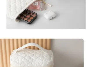 White quilted cosmetic bag detail view, large capacity travel makeup storage organizer.