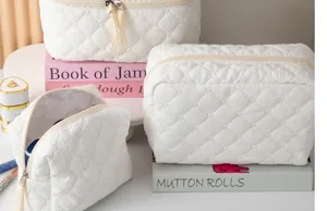 White quilted cosmetic bag detail, spacious makeup organizer with zipper closure for travel.