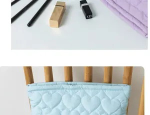 Quilted heart cosmetic bag detail view, soft blue fabric with cute stitched heart pattern for storage.