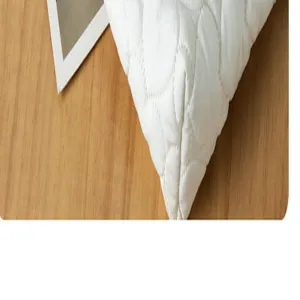 Detailed close-up view of the white quilted heart pattern fabric texture on a wooden surface.