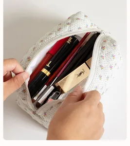 Vista dettagliata della borsa cosmetica trapuntata con ampio spazio interno per pennelli.