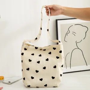 Canvas tote bag with black heart print, casual shoulder bag and large capacity handbag.