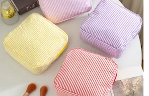 Detail shot of colorful striped seersucker cosmetic pouches, portable zipper storage bags.