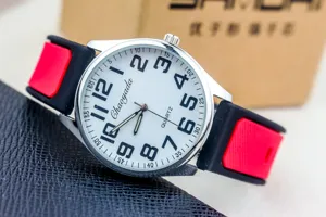 Close-up detail shot of quartz watch with white dial and bold numbers on silicone strap.