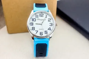 Quartz watch detail view, blue and black silicone strap, clear white dial with numbers.