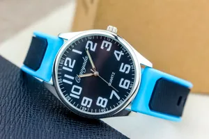 Detailed view of quartz watch with black dial, large Arabic numerals, and blue silicone strap.