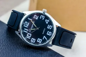Detailed close-up view of black dial quartz watch with clear white arabic numbers and silicone strap.