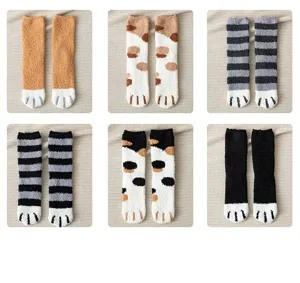 Detail view of cute fuzzy cat paw socks, soft coral fleece, warm winter home floor socks.