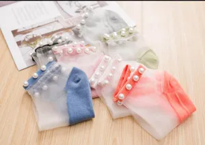 Primo piano di calzini corti in rete di cristallo da donna con eleganti polsini di perle trasparenti.