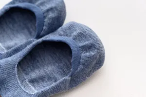 Detailed close-up view showing the soft knit texture and elastic rim of blue socks.