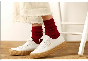 Canvas sneakers with red crew socks, casual footwear for women, stylish everyday wear.