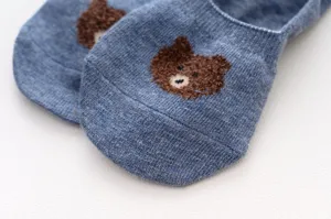 Close-up detail of cute brown bear embroidered blue women shallow boat socks, soft knit.