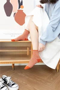 Close-up detail of retro plaid women's socks featuring cute ruffled lace cuffs and soft cotton.