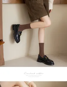 Detail shot of women's pure cotton mid-calf slouch socks paired with stylish black loafers.
