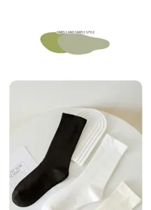 Close up detail of minimalist plain cotton crew socks in black, white, and beige colors.