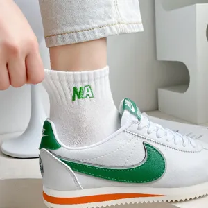 White cotton mid-tube socks with green letter embroidery, comfortable daily casual sportswear.